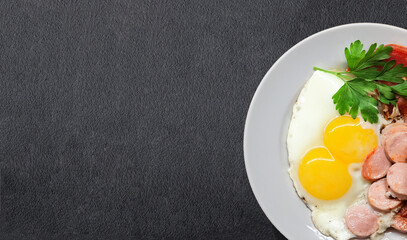 Fried eggs with fried tomatoes, sausages and parsley