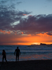 Fototapeta premium silhouette of a couple walking on the beach