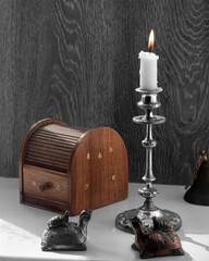 Stylish sketch with an antique candelabra and a candle.Antique bronze objects created the composition.Bronze figurines of a turtle adorned the morning still life.