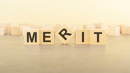 Obraz premium five wooden blocks with the letters MERIT on the surface table
