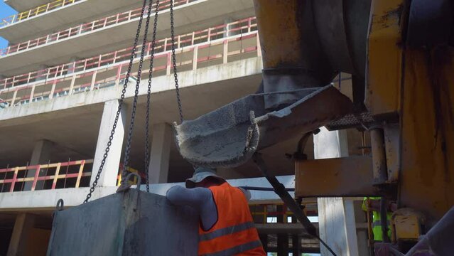 Mixer truck is transport cement to casting place on building site, Selective focus. Concrete is poured into container for transportation by crane to upper floors.