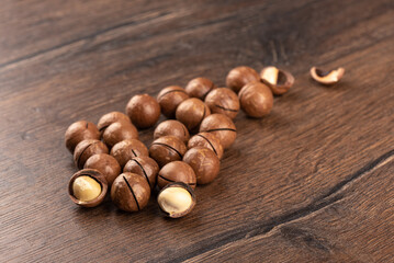 Selective focus on macadamia nuts over wooden background.