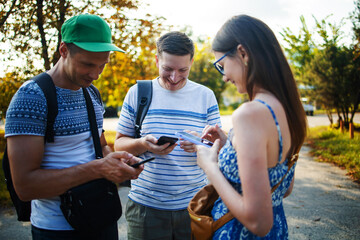 Three friend hands texting in their smart phones in the street with a blurred background