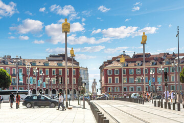 The seven statues art display representing the continents rise above Place Massena as tourists walk...