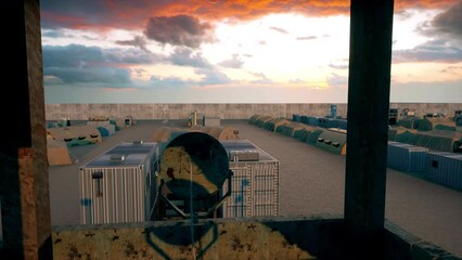 An abandoned and deserted secure military base and army camp in the middle of the desert as viewed from the top of the military base's watchtower.