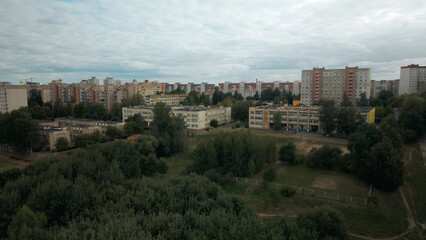 Fototapeta na wymiar City with high-rise buildings. Park area in the foreground. Blue sky with clouds. Aerial photography.
