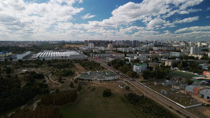 Obraz premium City with high-rise buildings. Park area in the foreground. Blue sky with clouds. Aerial photography.