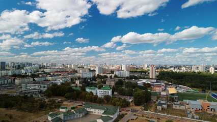 Naklejka premium City with high-rise buildings. Park area in the foreground. Blue sky with clouds. Aerial photography.