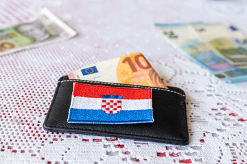 Wallet with a protruding 10 euro banknote and the symbol of Croatia, The concept of changing the...