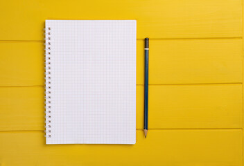 top view of a white notebook with a pencil. space for your text or design