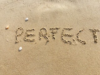 on the beach is carved with letters in the smooth sand the writing Perfect