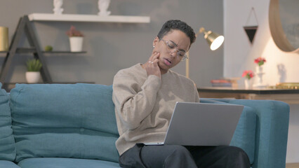 African Woman with Laptop having Toothache on Sofa