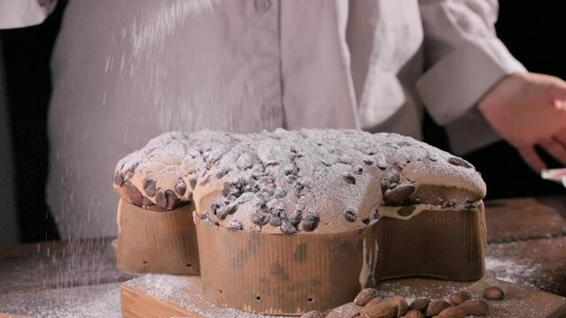 Easter dove in female hands . Colomba di Pasqua - traditional italian easter dove cake with glaze macaranage, almonds. Easter dove on a board. . High quality FullHD footage