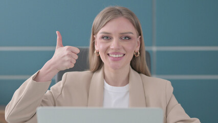 Close Up of Businesswoman Showing Thumbs Up Sign While using Laptop in Office