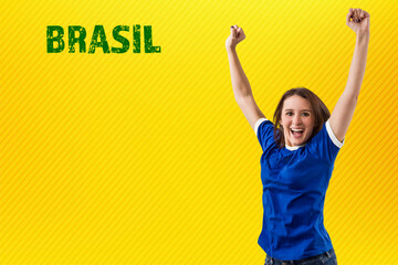 Female brazilian fan celebrating on a yellow background.