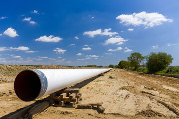 Fototapeta na wymiar Construction of an underground natural gas pipeline to provide energy to industry and households . Clear blue sky with white clouds.