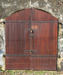 old door; old door in a wall; old door in a building; wooden door on a brown house; grey texture entrance and door to an old colonial house; big door with a metal latch from a world heritage site