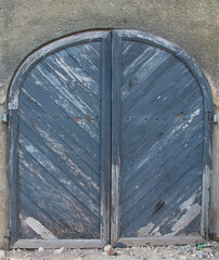 old door; old door in a wall; old door in a building; wooden door on a brown armoury; grey texture entrance and door to an old colonial house; big door with a metal latch from a world heritage site 