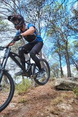 Fototapeta na wymiar Teenager in forest practicing downhill biking.