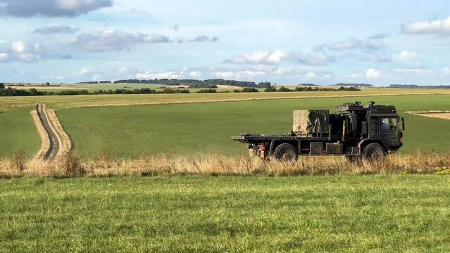 British army MAN HX60 SV 4x4 vehicle carrying a greight pallet on a dirt track in action on a military exercise