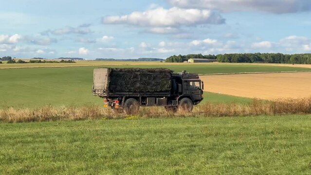 British army MAN HX60 SV 4x4 logistics lorry in action on a military exercise, blue sky with white cloud 