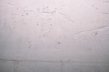 Texture of an old plastered white wall with deep scratches and cracks