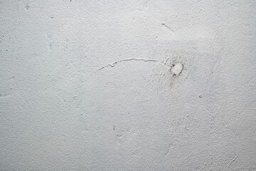 Texture of an old plastered white wall with deep scratches and cracks