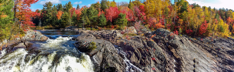 Panoramic view of the wild river flowing amidst rugged rocks and beautiful fall leaves, Massey, ON,...