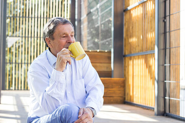 Smiling senior man enjoying in morning coffee