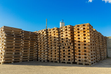 Stacks of wooden pallets in a warehouse yard of factory.