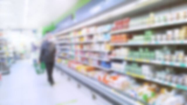 Abstract blur image of supermarket background. Defocused shelves with dairy products. Grocery. Retail industry. Rack. Discount. Inflation and economic crisis concept. Aisle. CPG. Store. Recession.