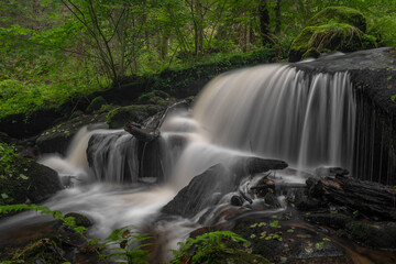 Obraz premium Waterfall under floodgate near Vyssi Brod town in cloudy summer day