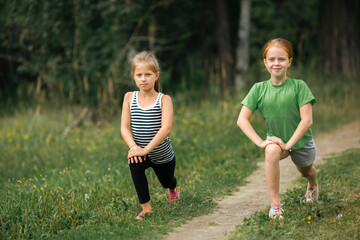 Two ten-year-old girls warming up before a jog in the park.
