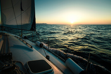 Fototapeta premium Sailing yacht boat in the Sea during amazing sunset.