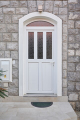 White plastic front door with glass on the facade of the house
