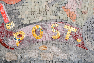 Post word composed by a mosaic of colorful stones.