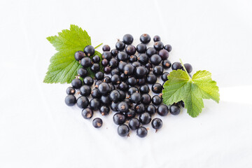 Fresh black berries with water drops and green leaves. Blackcurrants isolated on a white background with copy space for text. Black currant organic berries harvest - healthy eating and food concept