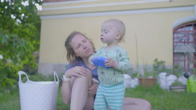 Mother Talking To Cute Boy With Toy In Backyard - Jablonec nad Nisou, Czech Republic
