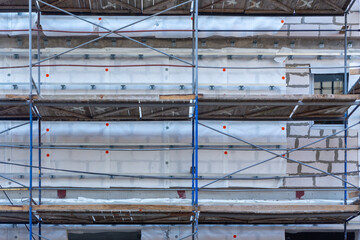 Insulation of the exterior walls of a building under construction.