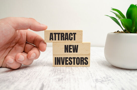 Attract new Investors words on wooden blocks