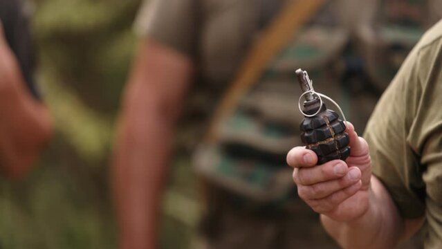 Hand grenade in soldier's hand, realistic hand grenade, smoke grenade, high explosive TNT