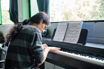 Concentrated piano teacher playing classical music