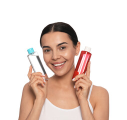 Young woman with bottles of micellar water on white background