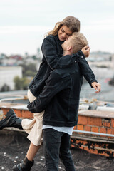 Beautiful happy young loving couple on a surprise date on a Saint Valentine's Day. Romantic modern wedding on the rooftop, summertime. Young man and beautiful girl. Newlyweds on honeymoon