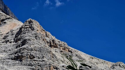 Val Badia, Italy-July 18, 2022: The italian Dolomites behind the small village of Corvara in summer days with beaitiful blue sky in the background. Green nature in the middle of the rocks.