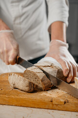 Male chef's hands cut bread