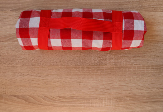 Folded Checkered Picnic Blanket On Wooden Table, Top View. Space For Text