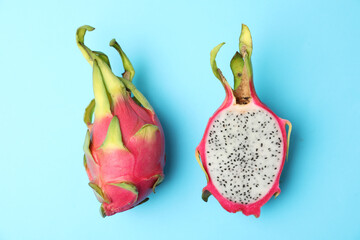 Delicious ripe dragon fruits (pitahaya) on light blue background, flat lay