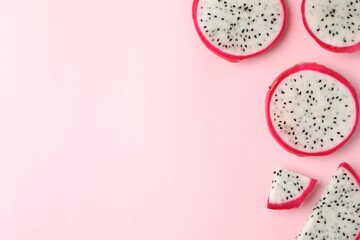 Slices of delicious dragon fruit (pitahaya) on pink background, flat lay. Space for text