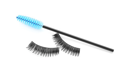 Fake eyelashes and brush on white background